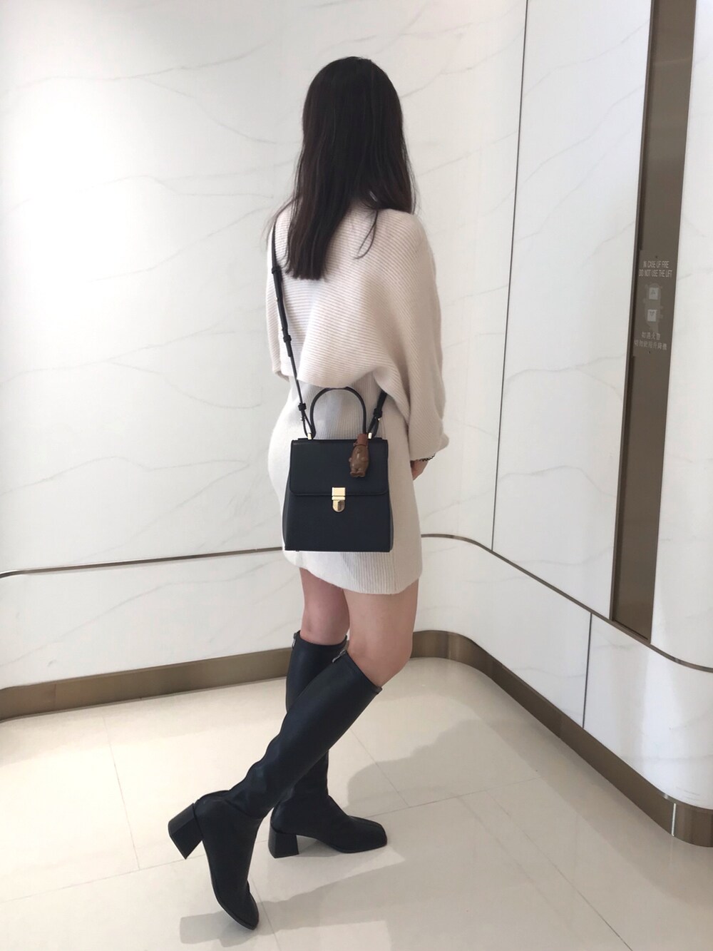 ブラック系のブーツを着用したレディースの冬コーディネートの3枚目の写真