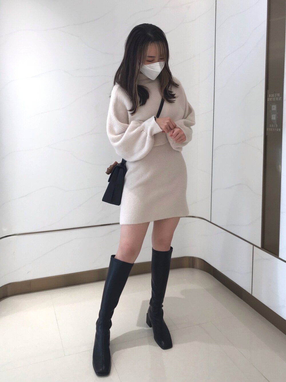 ブラック系のブーツを着用したレディースの冬コーディネートの2枚目の写真