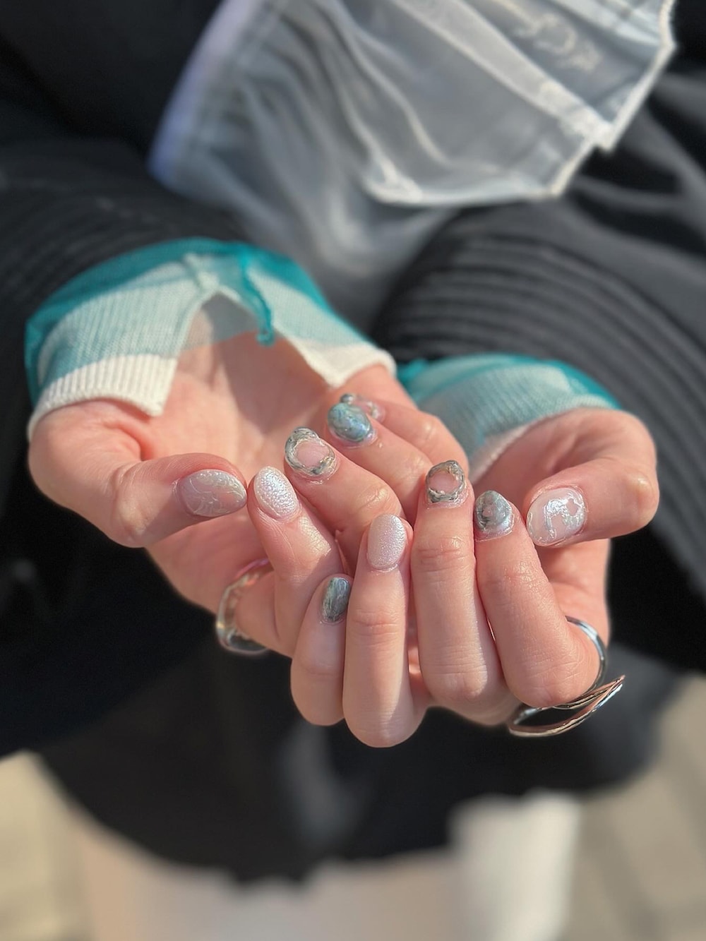 ブラック系のノーカラーコート、シルバー系のショルダーバッグ、ベージュ系のスカートを着用したレディースの冬コーディネートの3枚目の写真