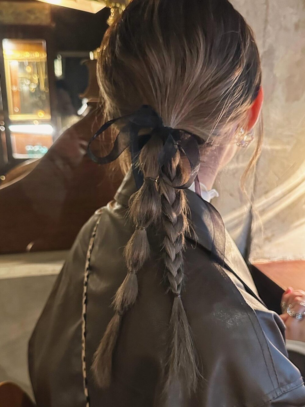 ブラウン系のライダースジャケットを着用したレディースの春コーディネートの2枚目の写真