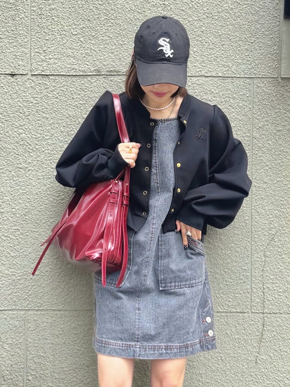 グレー系のワンピース、ブラック系のカーディガン/ボレロ、グレー系のTシャツ/カットソーを着用したレディースの春コーディネートの2枚目の写真