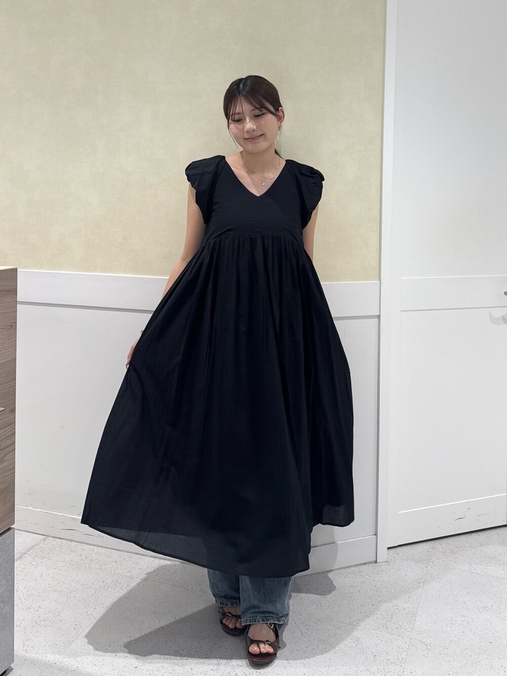 ブラック系のワンピースを着用したレディースの夏コーディネートの2枚目の写真