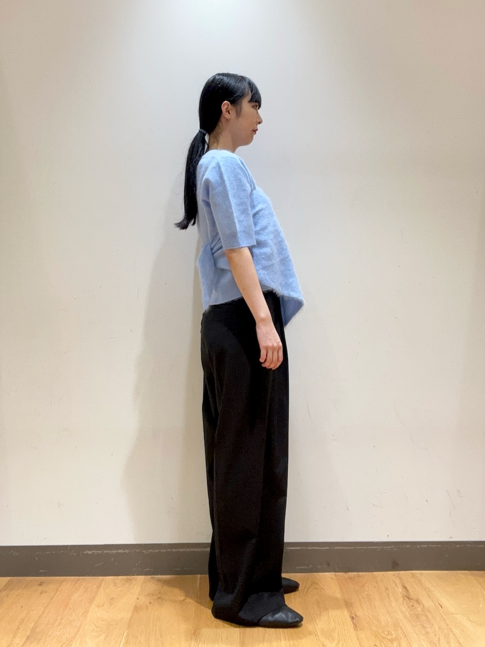 ブルー系のニット/セーター、ブルー系のハンドバッグ、ブラック系のその他パンツを着用したレディースの秋コーディネートの2枚目の写真