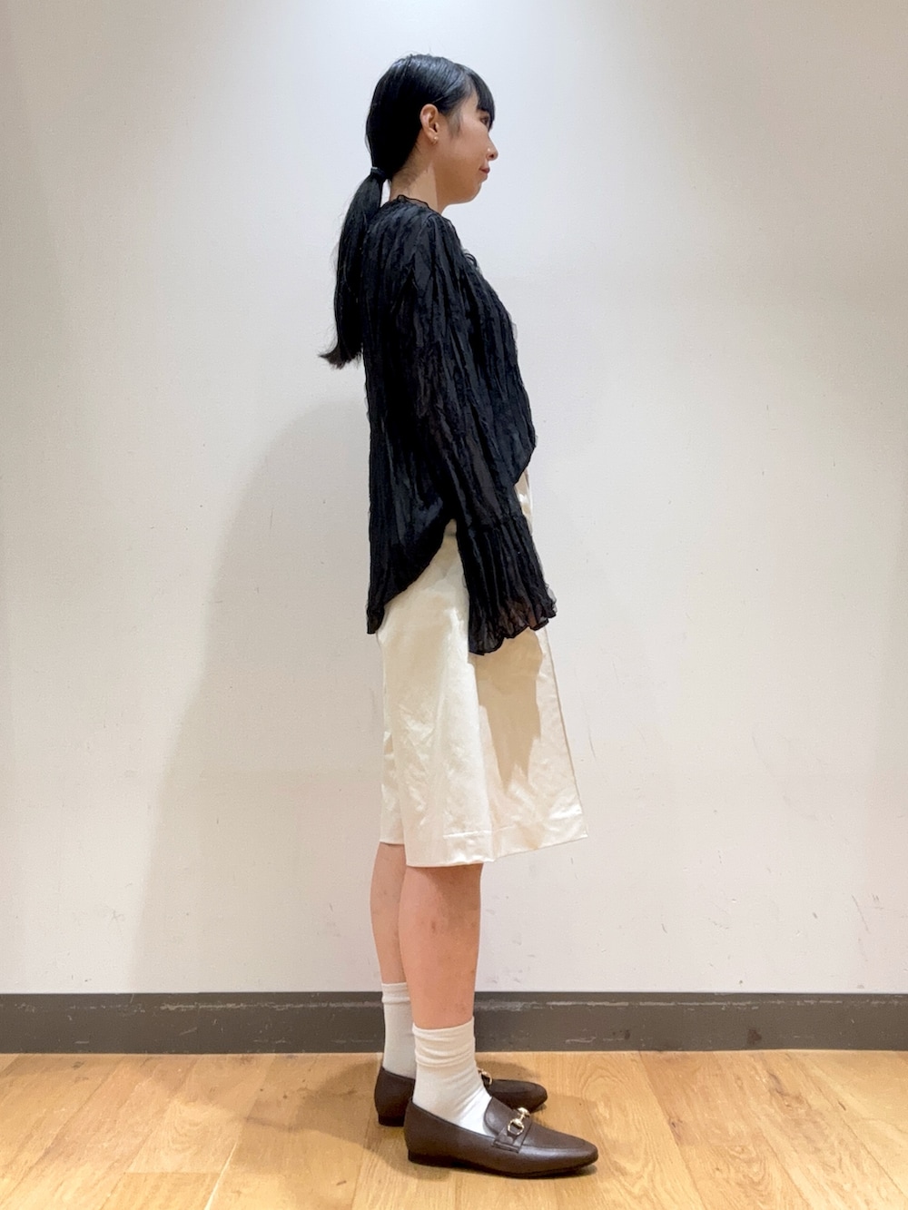 ブラック系のシャツ/ブラウス、ホワイト系のその他パンツ、ブラウン系のローファーを着用したレディースの秋コーディネートの2枚目の写真