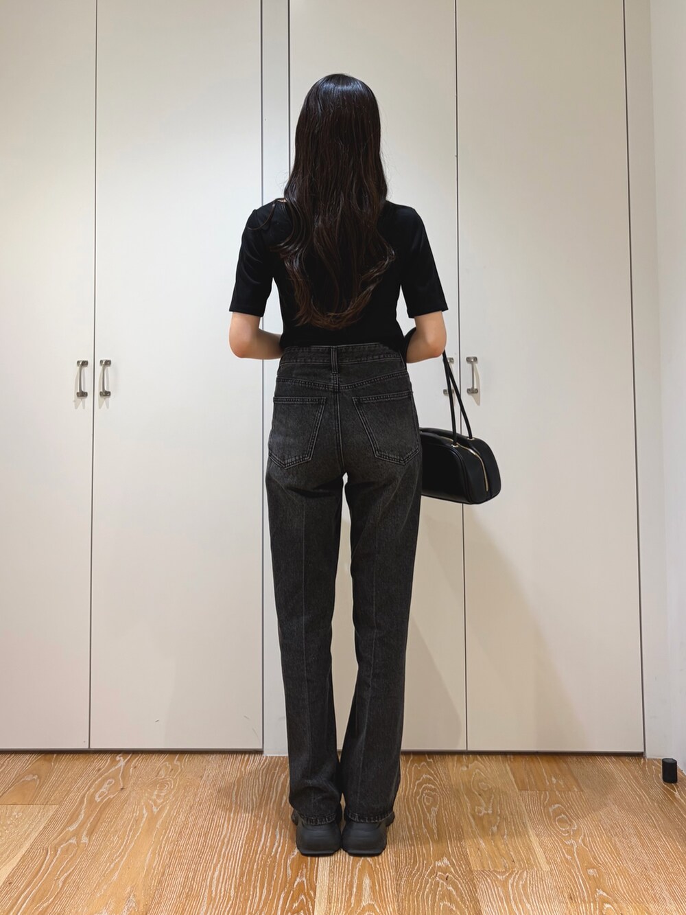 ブラック系のその他パンツ、ブラック系のTシャツ/カットソー、ブラック系のボストンバッグを着用したレディースの秋コーディネートの4枚目の写真
