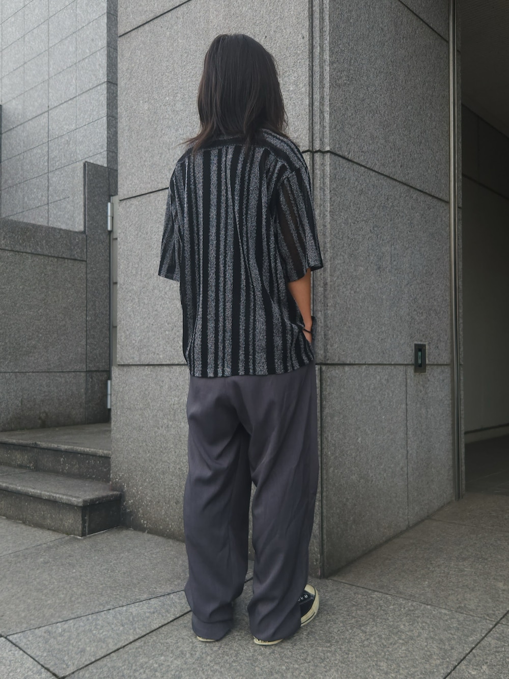 グレー系のスラックス、ブラック系のシャツ/ブラウス、ブラック系のスニーカーを着用したメンズの夏コーディネートの3枚目の写真