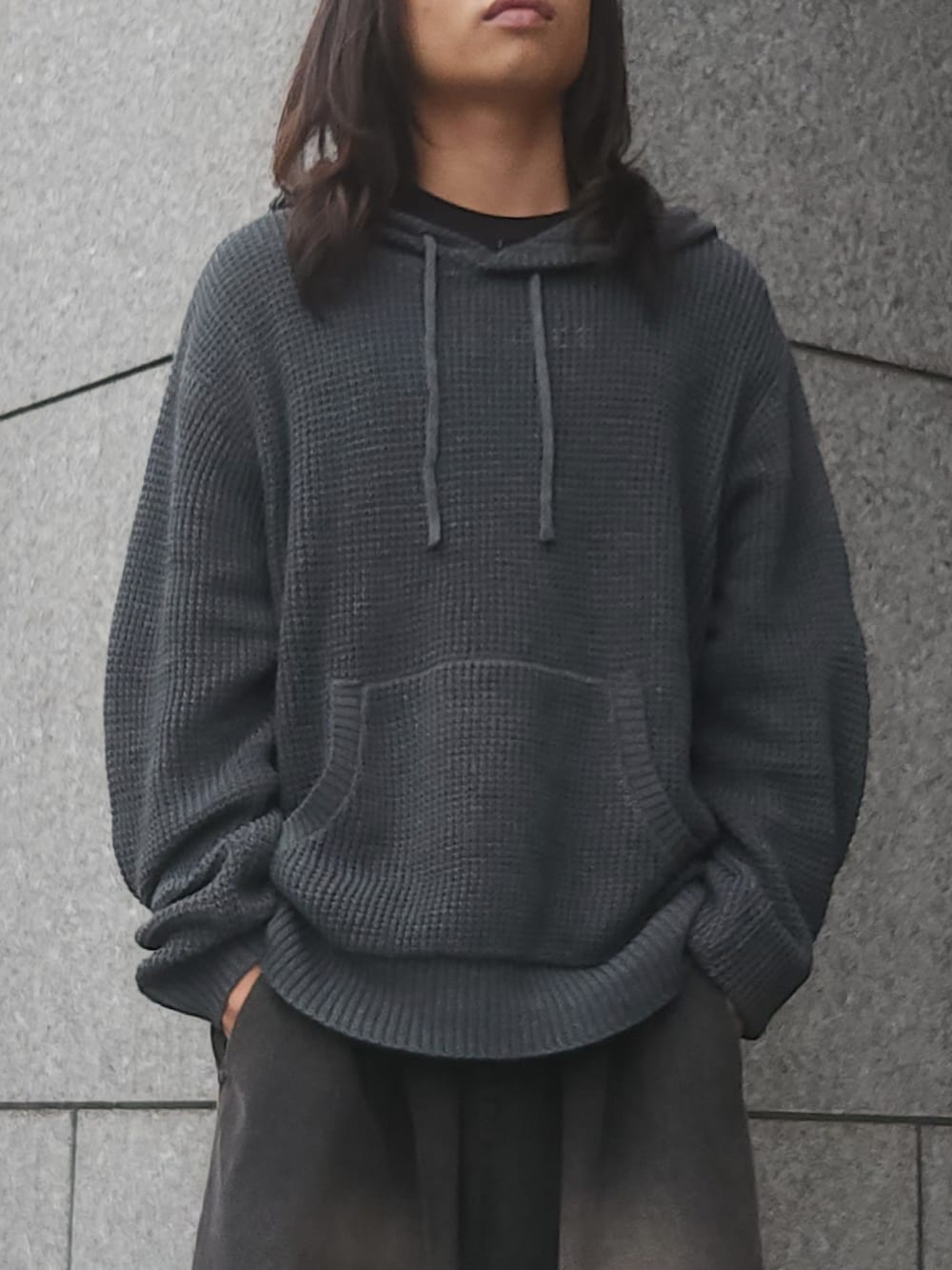 グレー系のパーカー、ブラック系のデニムパンツ、ブラック系のスニーカーを着用したメンズの秋コーディネートの2枚目の写真