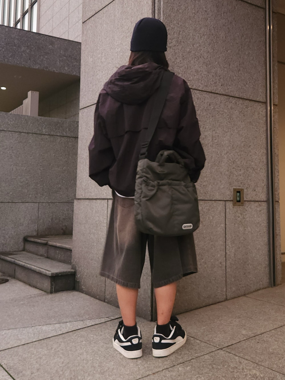 ブラック系のブルゾン、ブラック系のデニムパンツ、グリーン系のショルダーバッグを着用したメンズの秋コーディネートの3枚目の写真