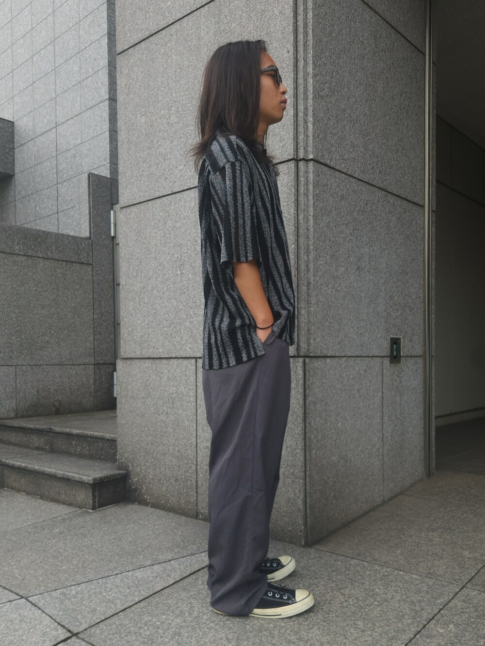 グレー系のスラックス、ブラック系のシャツ/ブラウス、ブラック系のスニーカーを着用したメンズの夏コーディネートの2枚目の写真