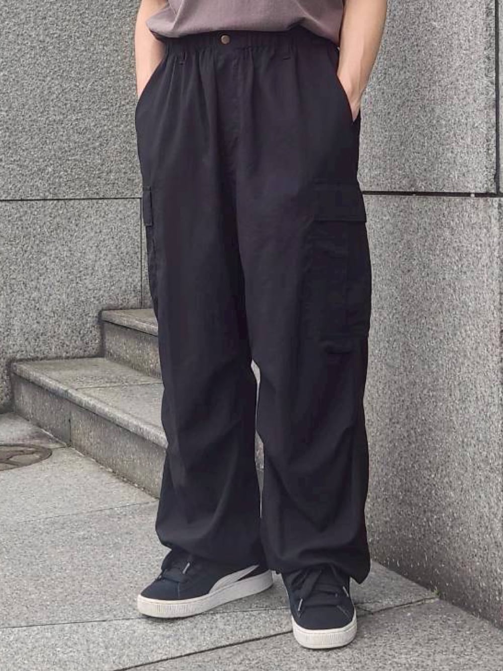 グレー系のTシャツ/カットソー、ブラック系のカーゴパンツ、ブラック系のスニーカーを着用したメンズの夏コーディネートの3枚目の写真