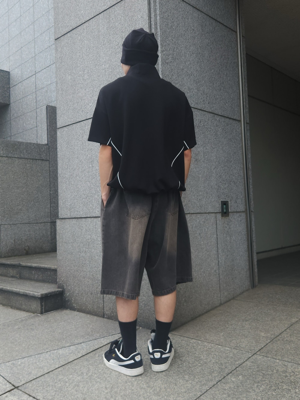 ブラック系のTシャツ/カットソー、ブラック系のデニムパンツ、ブラック系のスニーカーを着用したメンズの夏コーディネートの2枚目の写真