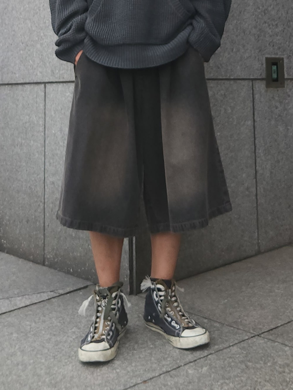 グレー系のパーカー、ブラック系のデニムパンツ、ブラック系のスニーカーを着用したメンズの秋コーディネートの3枚目の写真