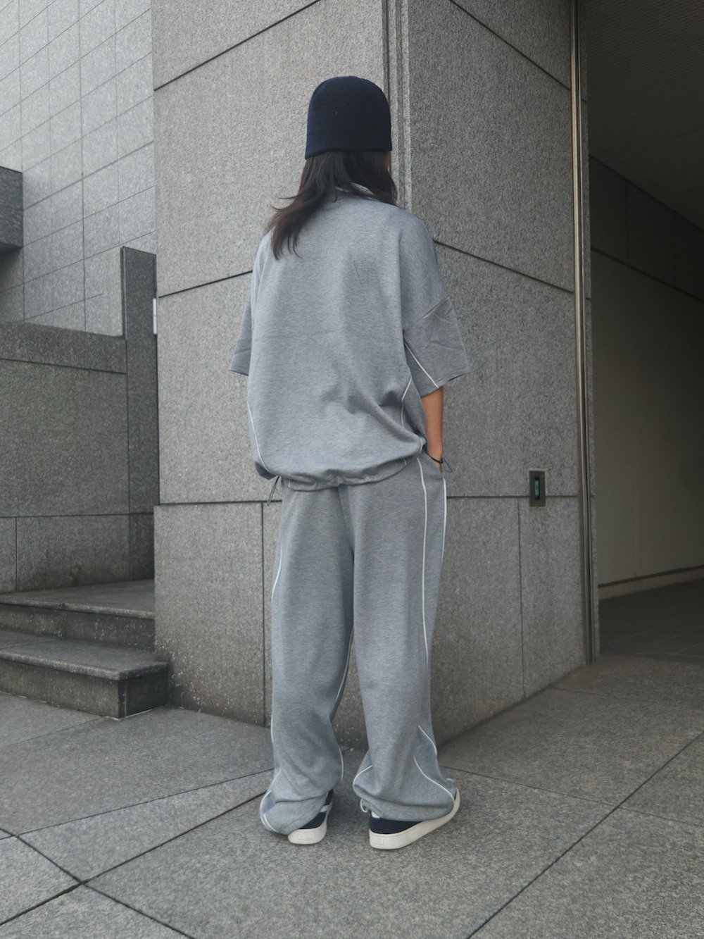 グレー系のその他パンツ、グレー系のTシャツ/カットソー、ブラック系のスニーカーを着用したメンズの夏コーディネートの2枚目の写真