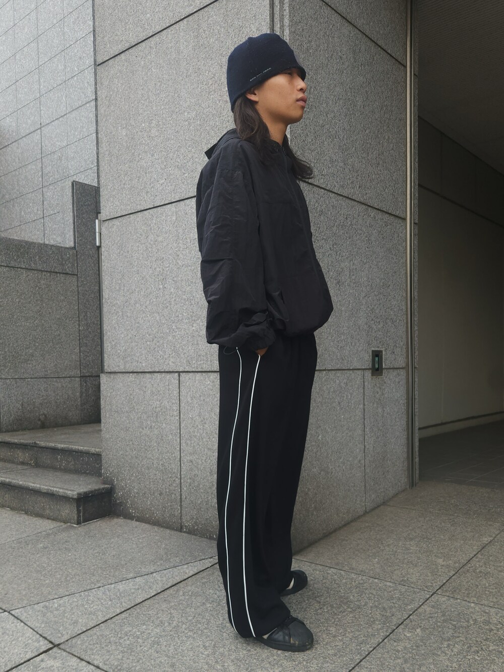 ブラック系のブルゾン、ブラック系のその他パンツ、ブラック系のスニーカーを着用したメンズの夏コーディネートの2枚目の写真