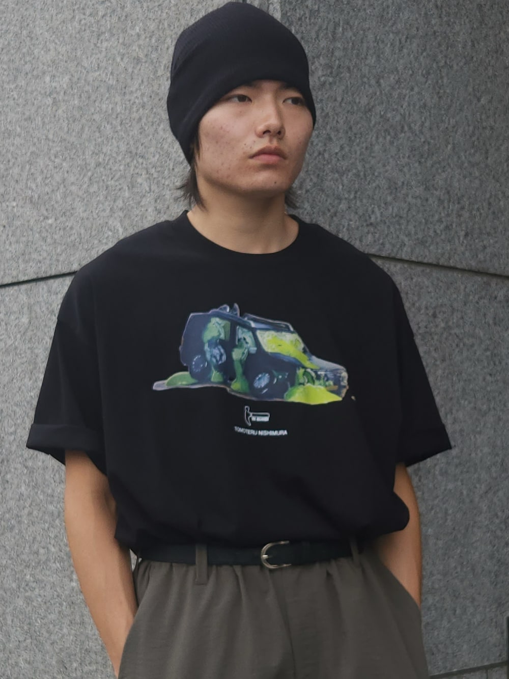 グリーン系のカーゴパンツ、ブラック系のTシャツ/カットソー、ブラック系のスニーカーを着用したメンズの夏コーディネートの3枚目の写真