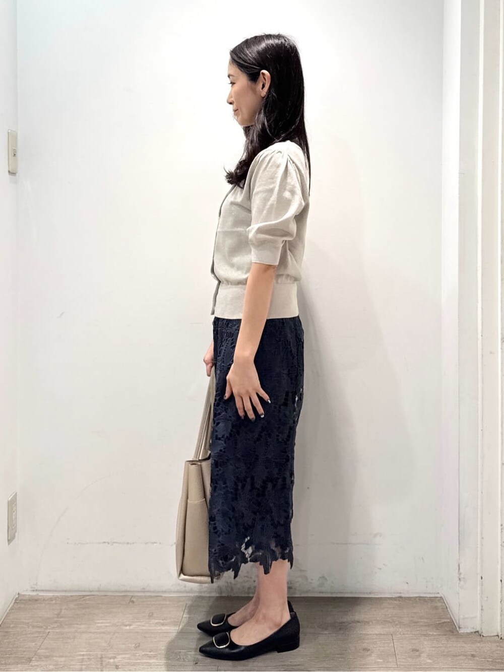 ベージュ系のカーディガン/ボレロ、ブルー系のスカート、ベージュ系のトートバッグを着用したレディースの秋コーディネートの4枚目の写真