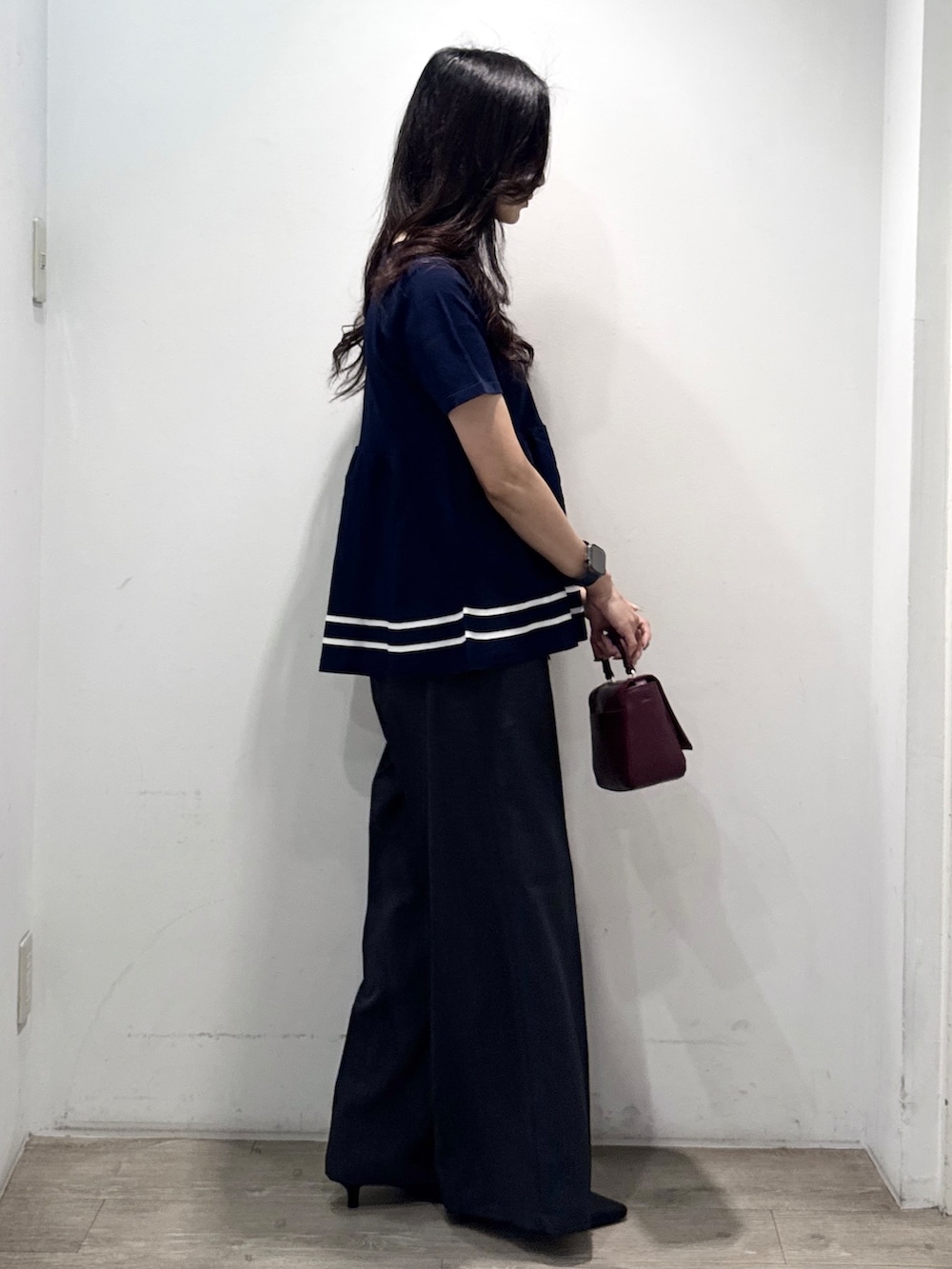 ブルー系のニット/セーター、グレー系のその他パンツ、レッド系のショルダーバッグを着用したレディースの夏コーディネートの9枚目の写真