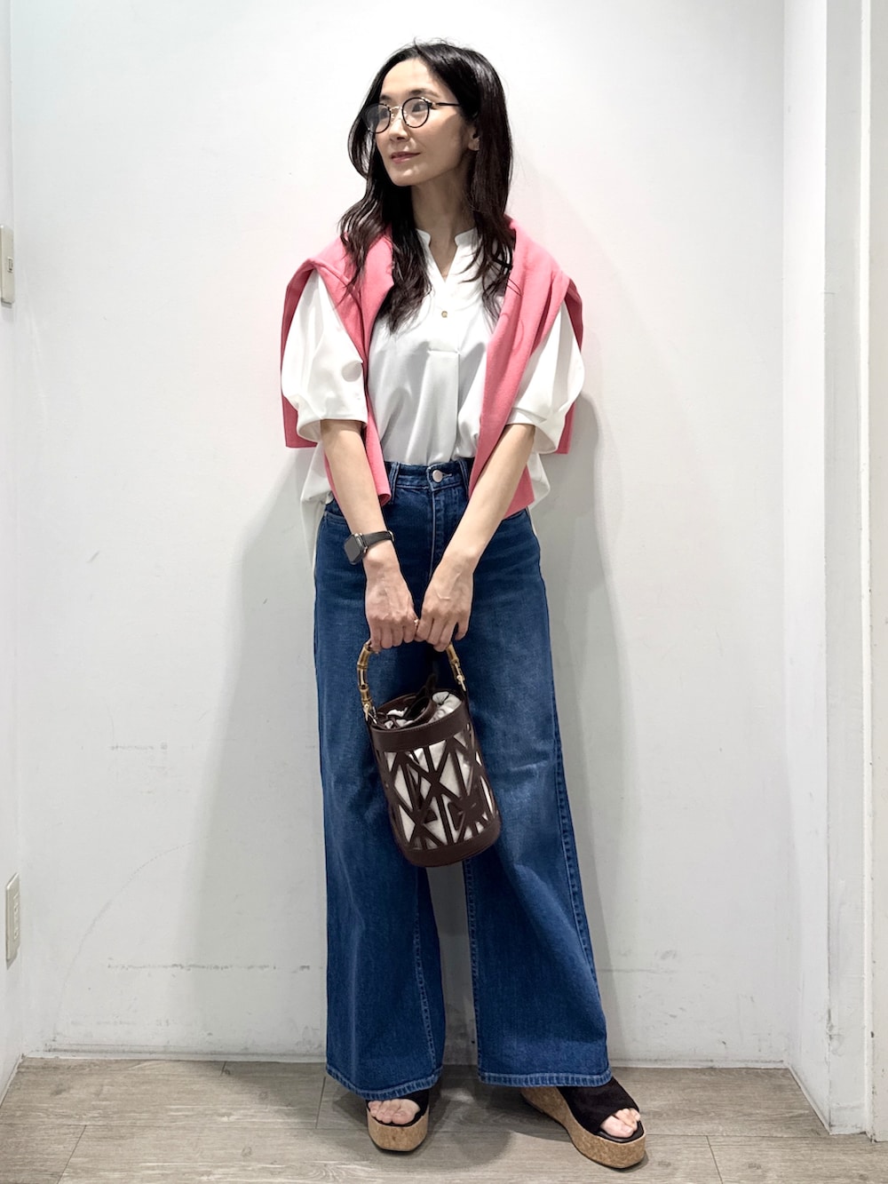 ブルー系のデニムパンツ、ホワイト系のシャツ/ブラウス、ブラウン系のハンドバッグを着用したレディースの春コーディネートの5枚目の写真
