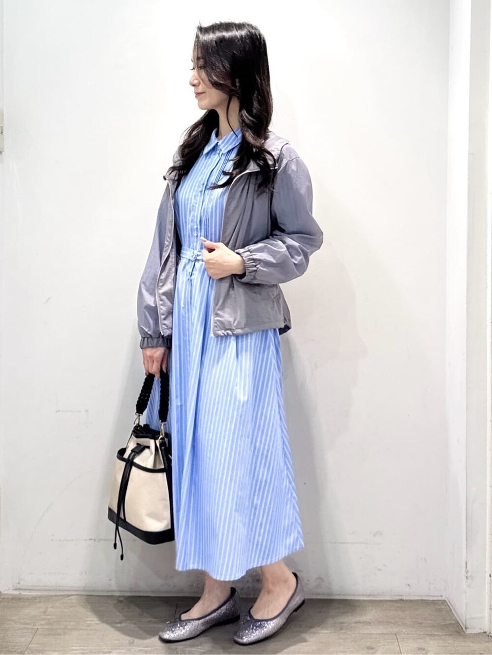 シルバー系のパンプス、ブルー系のワンピース、グレー系のブルゾンを着用したレディースの春コーディネートの8枚目の写真