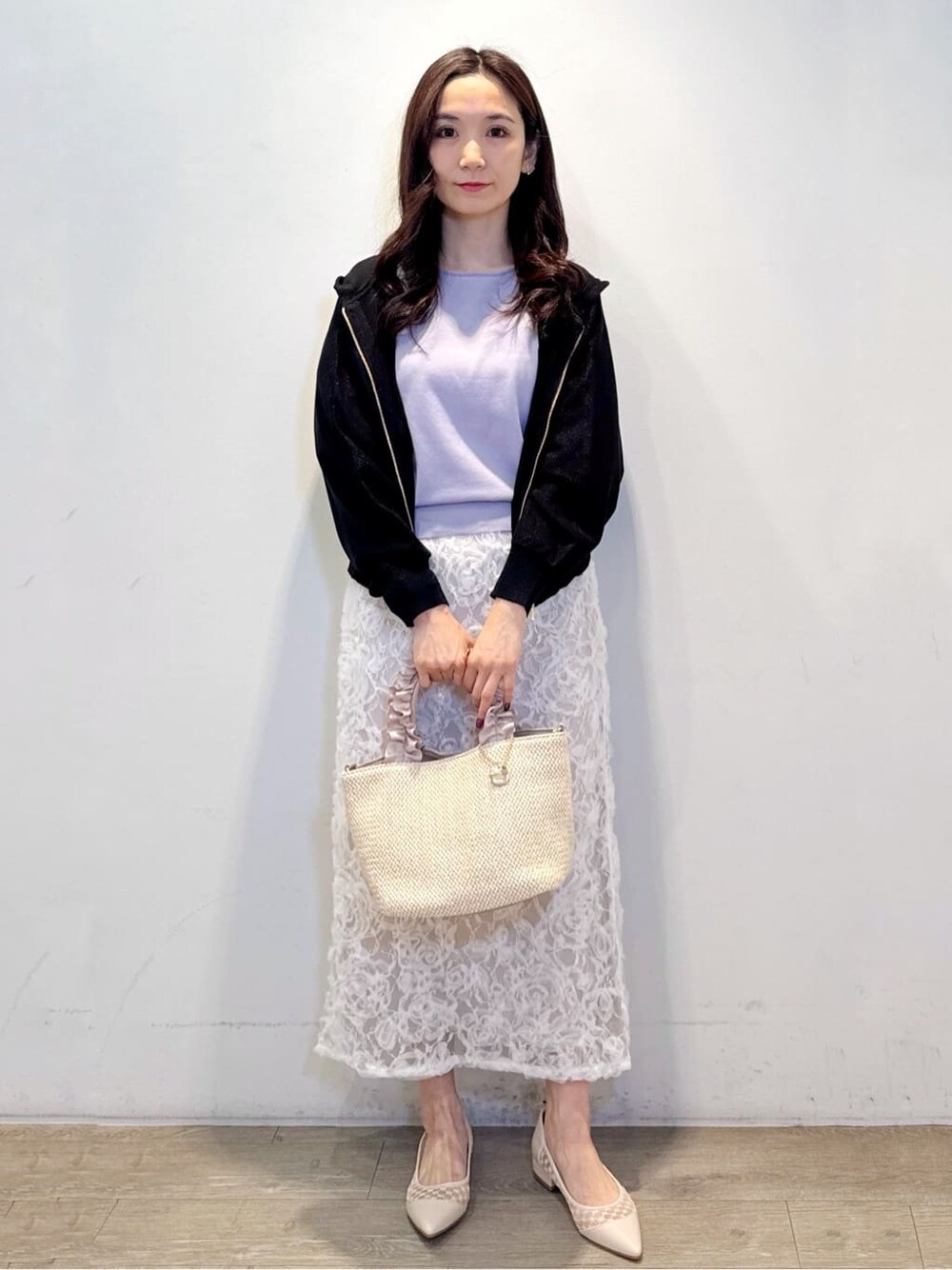 パープル系のニット/セーター、ホワイト系のスカート、ベージュ系のパンプスを着用したレディースの春コーディネートの2枚目の写真