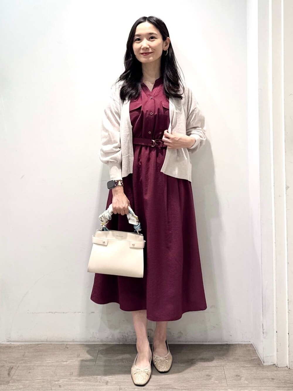 ベージュ系のカーディガン/ボレロ、レッド系のワンピース、ホワイト系のショルダーバッグを着用したレディースの秋コーディネートの3枚目の写真