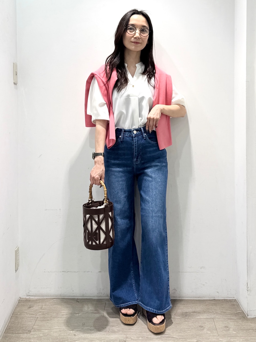 ブルー系のデニムパンツ、ホワイト系のシャツ/ブラウス、ブラウン系のハンドバッグを着用したレディースの春コーディネートの4枚目の写真