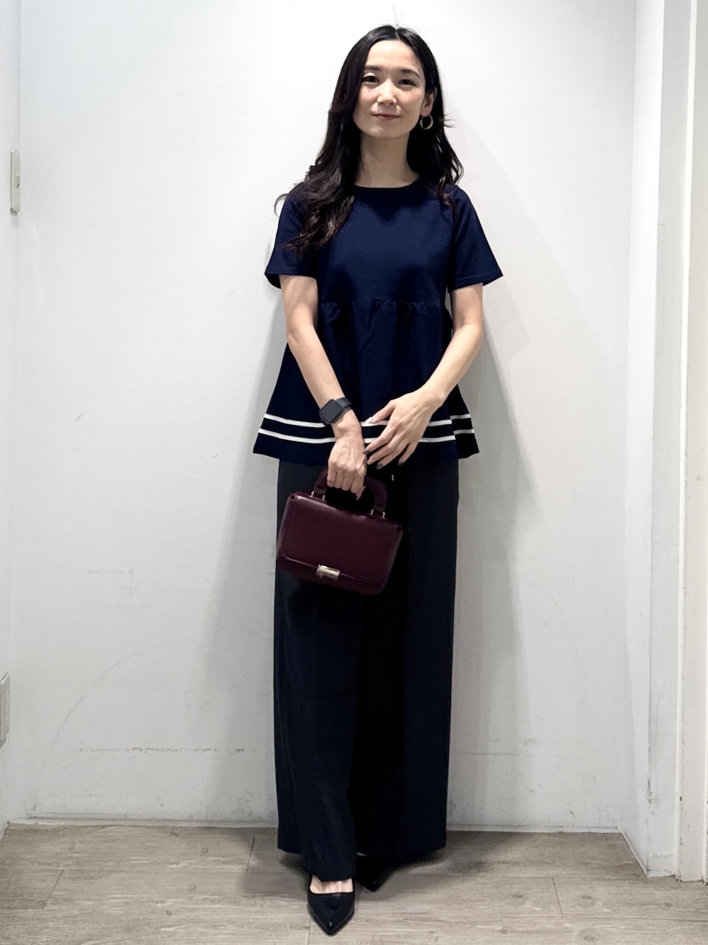 ブルー系のニット/セーター、グレー系のその他パンツ、レッド系のショルダーバッグを着用したレディースの夏コーディネートの4枚目の写真