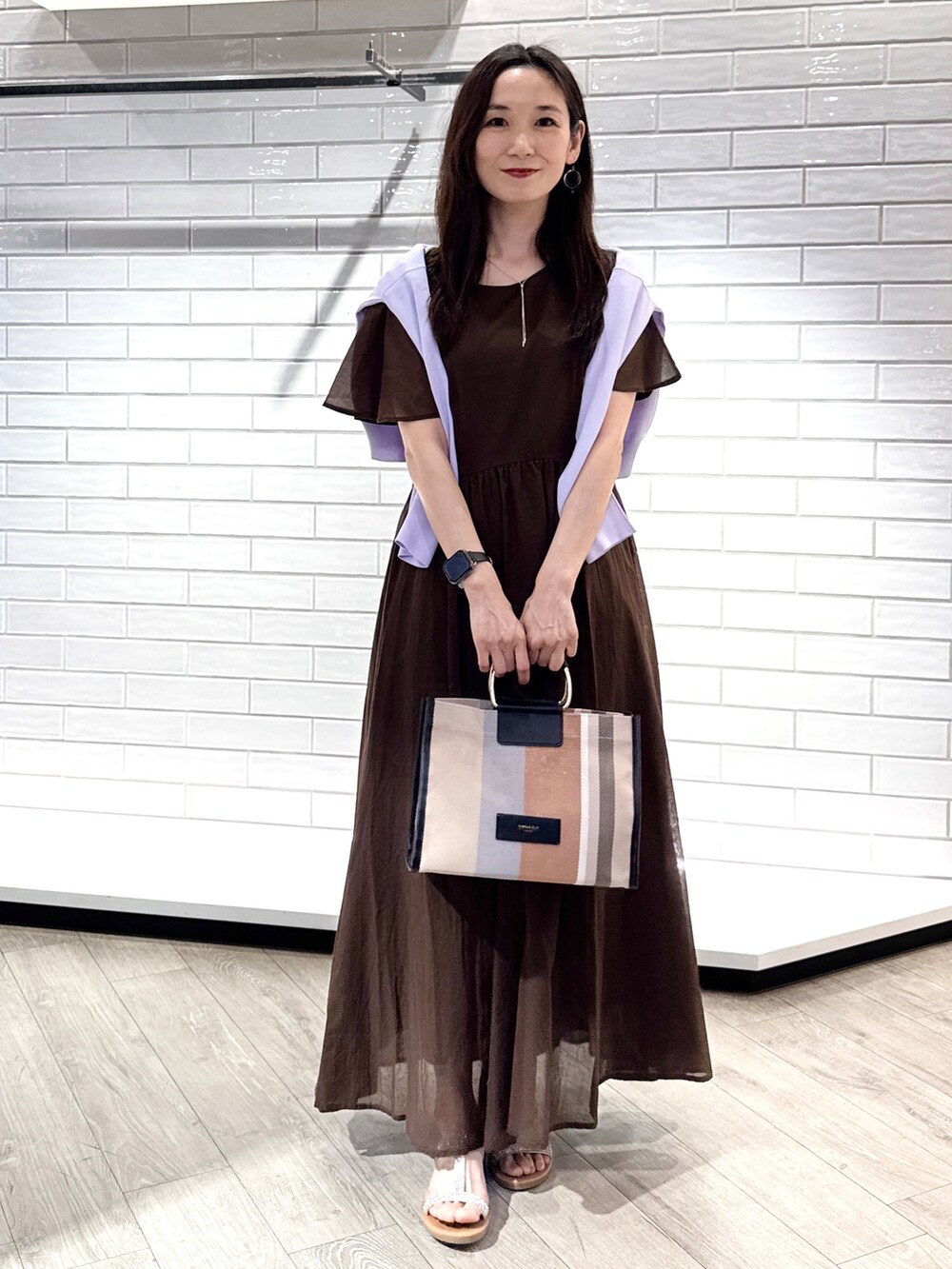 パープル系のカーディガン/ボレロ、ブラウン系のワンピース、ブラック系のトートバッグを着用したレディースの夏コーディネートの4枚目の写真