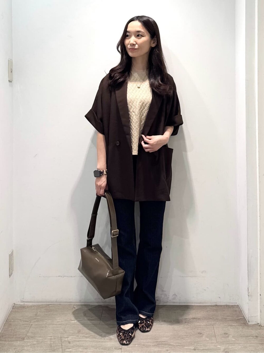 ブラウン系のテーラードジャケット、ベージュ系のTシャツ/カットソー、ブルー系のデニムパンツを着用したレディースの秋コーディネートの3枚目の写真