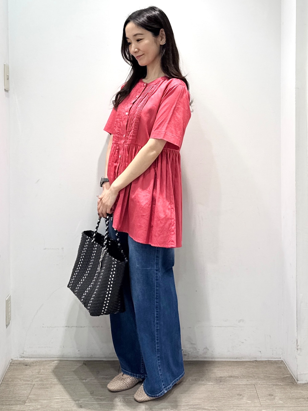 ブルー系のデニムパンツ、ブラック系のトートバッグ、ベージュ系のパンプスを着用したレディースの春コーディネートの8枚目の写真