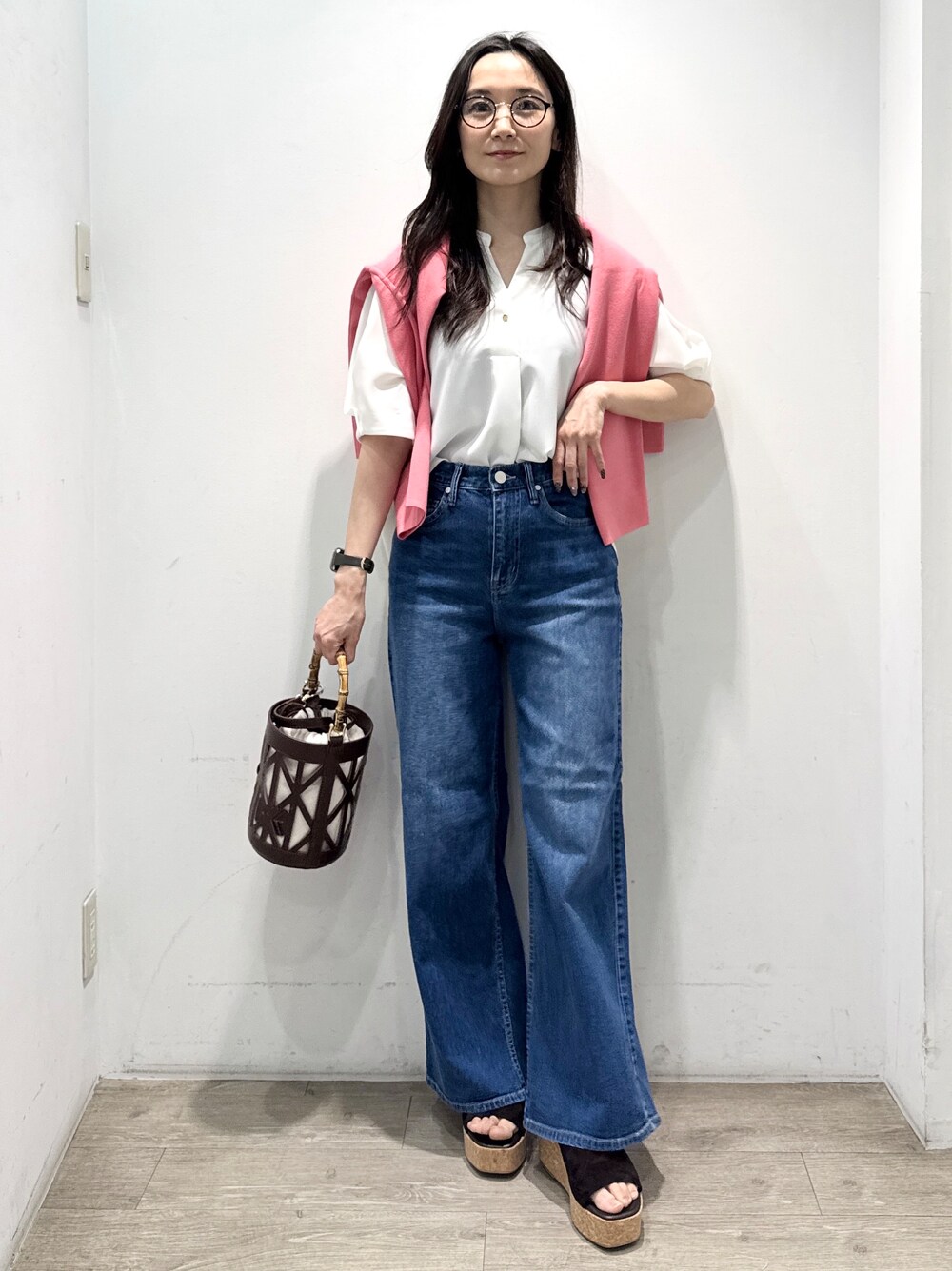 ブルー系のデニムパンツ、ホワイト系のシャツ/ブラウス、ブラウン系のハンドバッグを着用したレディースの春コーディネートの6枚目の写真