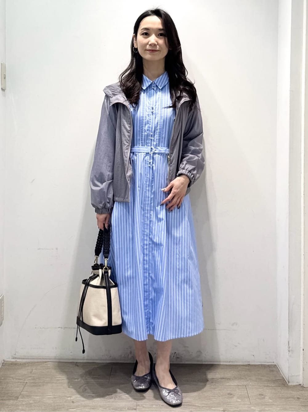 シルバー系のパンプス、ブルー系のワンピース、グレー系のブルゾンを着用したレディースの春コーディネートの4枚目の写真