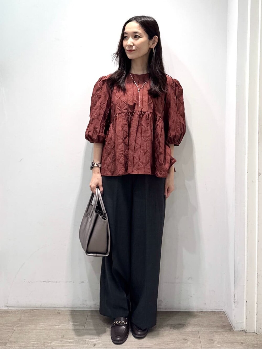 ブラウン系のシャツ/ブラウス、グレー系のその他パンツ、シルバー系のショルダーバッグを着用したレディースの秋コーディネートの2枚目の写真