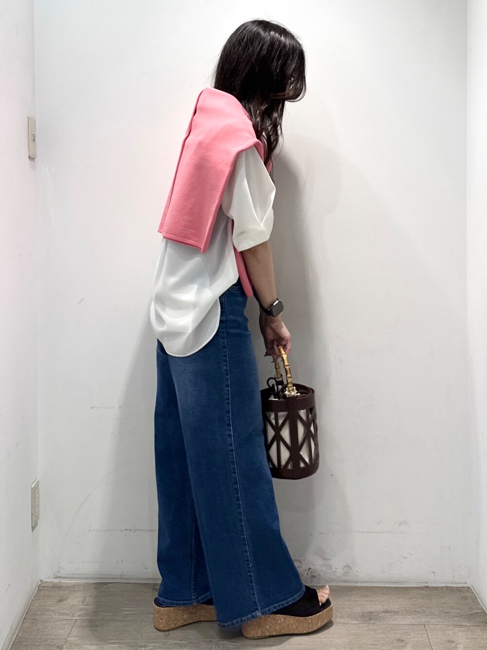 ブルー系のデニムパンツ、ホワイト系のシャツ/ブラウス、ブラウン系のハンドバッグを着用したレディースの春コーディネートの7枚目の写真