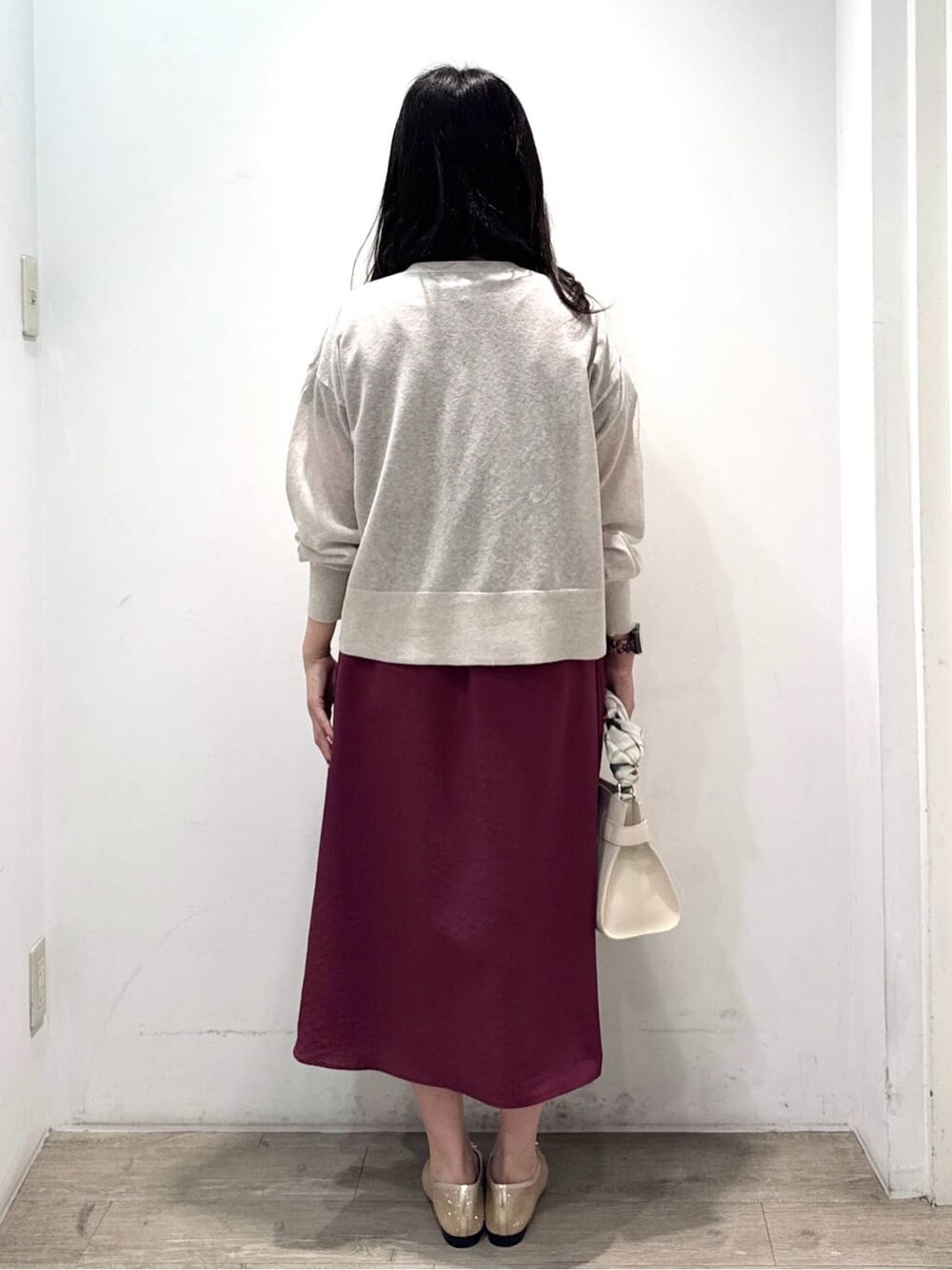 ベージュ系のカーディガン/ボレロ、レッド系のワンピース、ホワイト系のショルダーバッグを着用したレディースの秋コーディネートの10枚目の写真