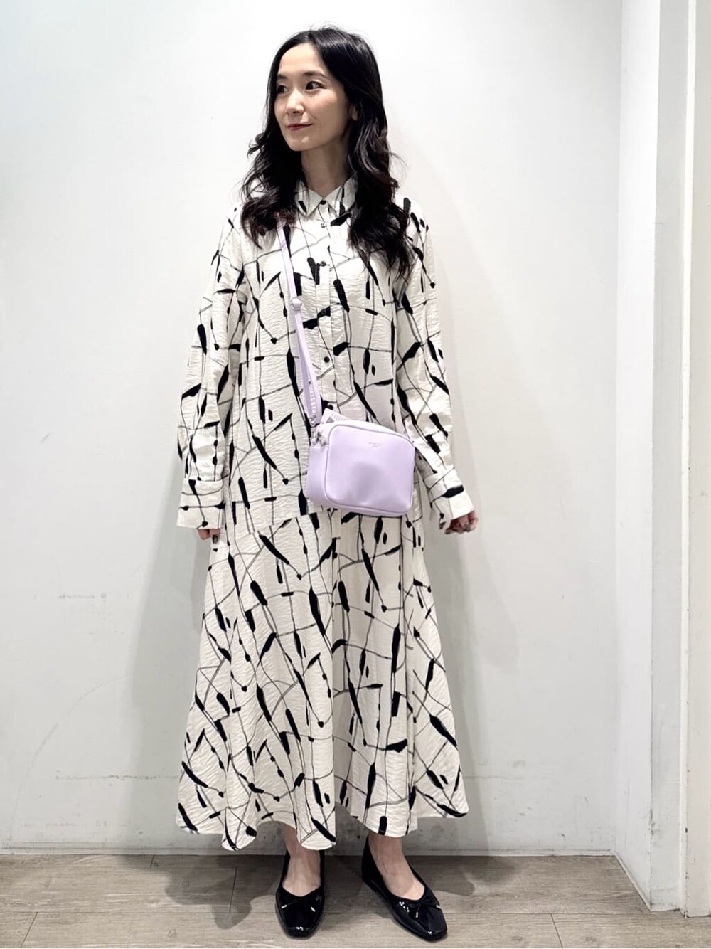 ベージュ系のワンピース、パープル系のショルダーバッグ、ブラック系のパンプスを着用したレディースの春コーディネートの4枚目の写真