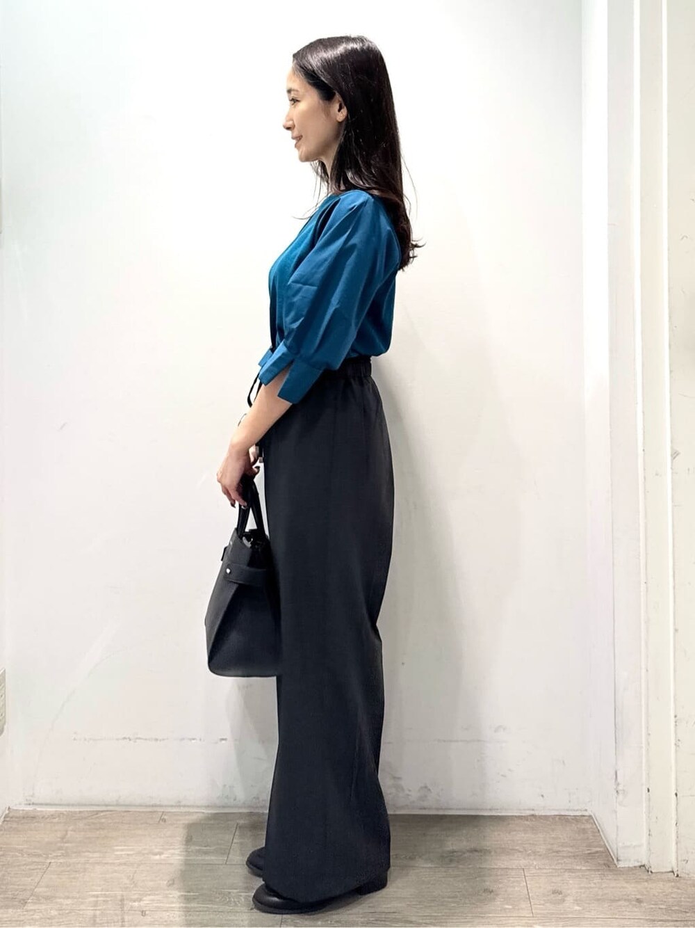 ブルー系のニット/セーター、グレー系のその他パンツ、ブラック系のショルダーバッグを着用したレディースの秋コーディネートの8枚目の写真