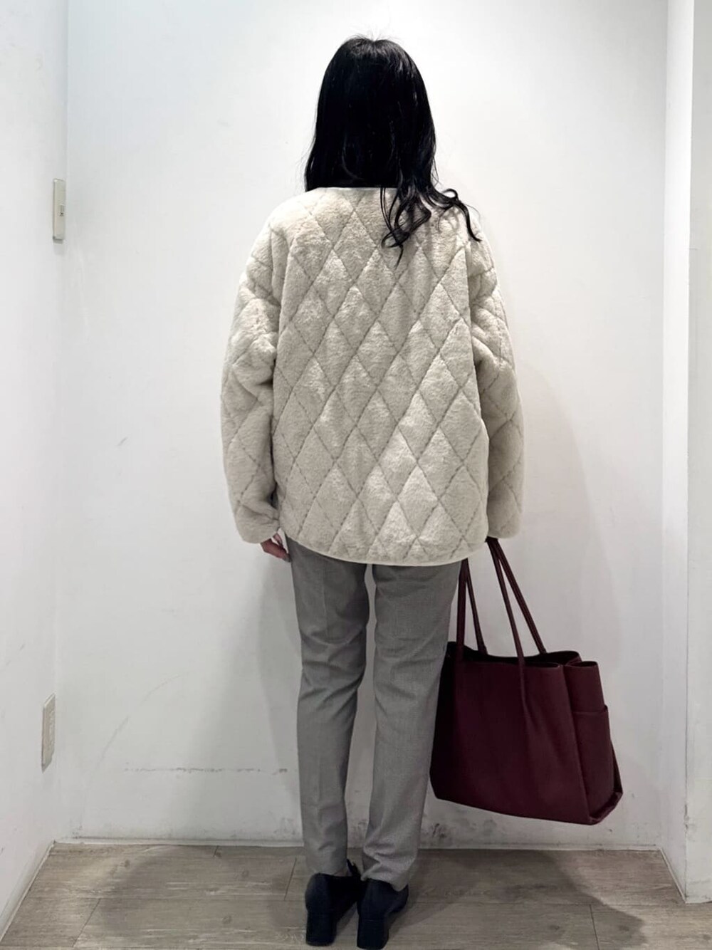 ホワイト系のブルゾン、ブラウン系のカーディガン/ボレロ、ブラック系のその他パンツを着用したレディースの秋コーディネートの10枚目の写真