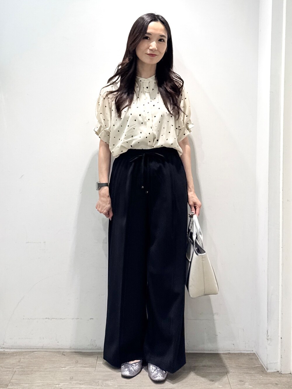 シルバー系のパンプス、ブラック系のその他パンツ、シルバー系のトートバッグを着用したレディースの春コーディネートの6枚目の写真