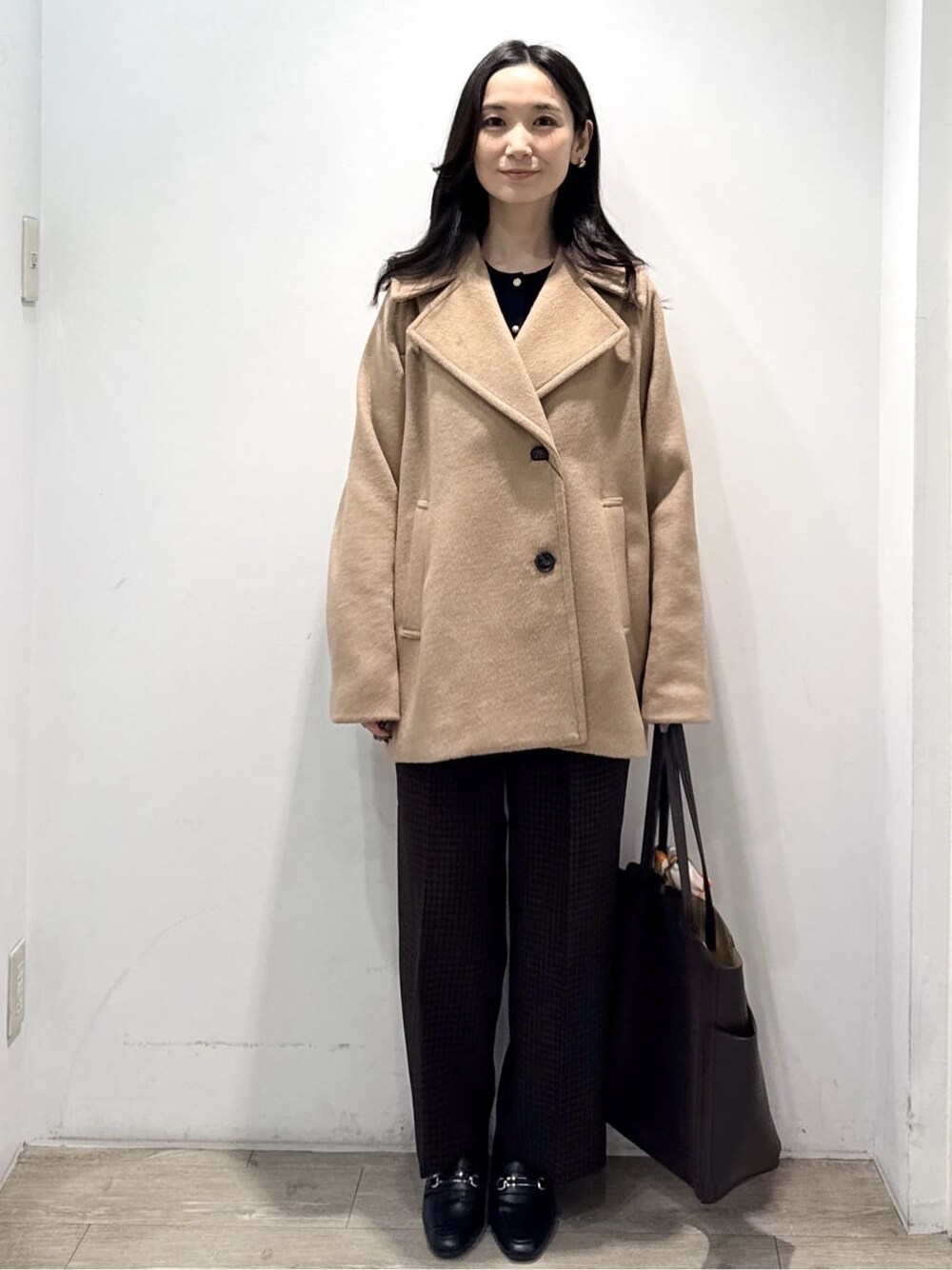 ベージュ系のピーコート、ブルー系のカーディガン/ボレロ、ブラウン系のその他パンツを着用したレディースの冬コーディネートの4枚目の写真