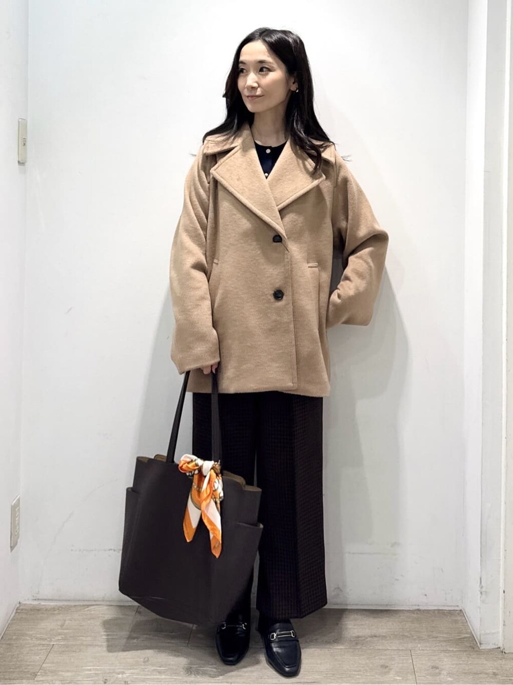 ベージュ系のピーコート、ブルー系のカーディガン/ボレロ、ブラウン系のその他パンツを着用したレディースの冬コーディネートの3枚目の写真