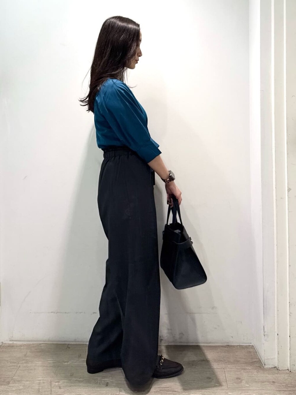 ブルー系のニット/セーター、グレー系のその他パンツ、ブラック系のショルダーバッグを着用したレディースの秋コーディネートの7枚目の写真