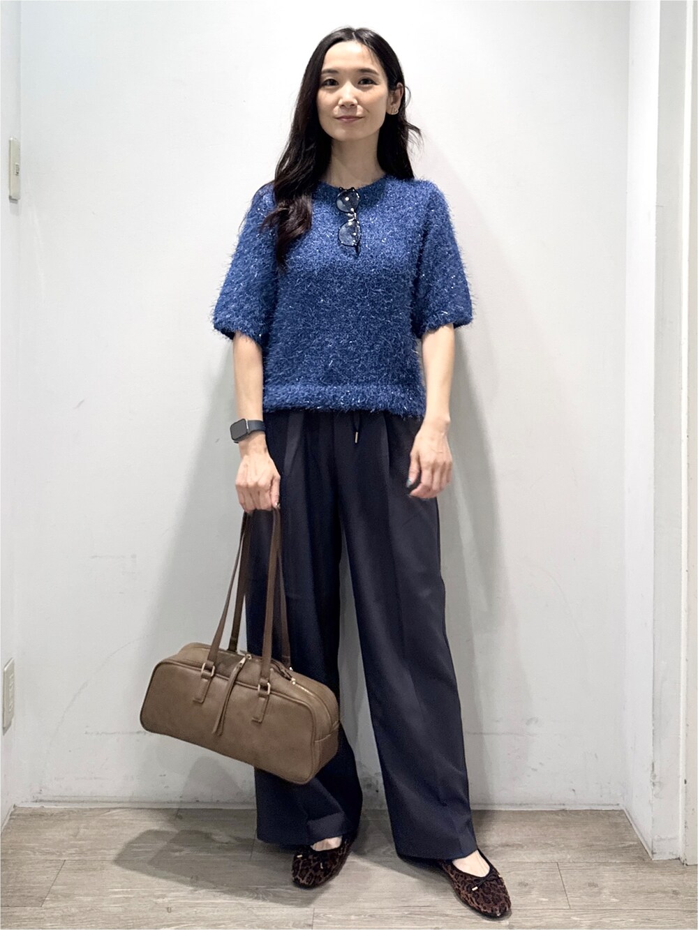 ブルー系のニット/セーター、グレー系のその他パンツ、イエロー系のボストンバッグを着用したレディースの秋コーディネートの3枚目の写真