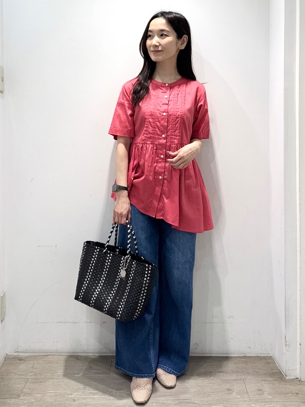 ブルー系のデニムパンツ、ブラック系のトートバッグ、ベージュ系のパンプスを着用したレディースの春コーディネートの3枚目の写真