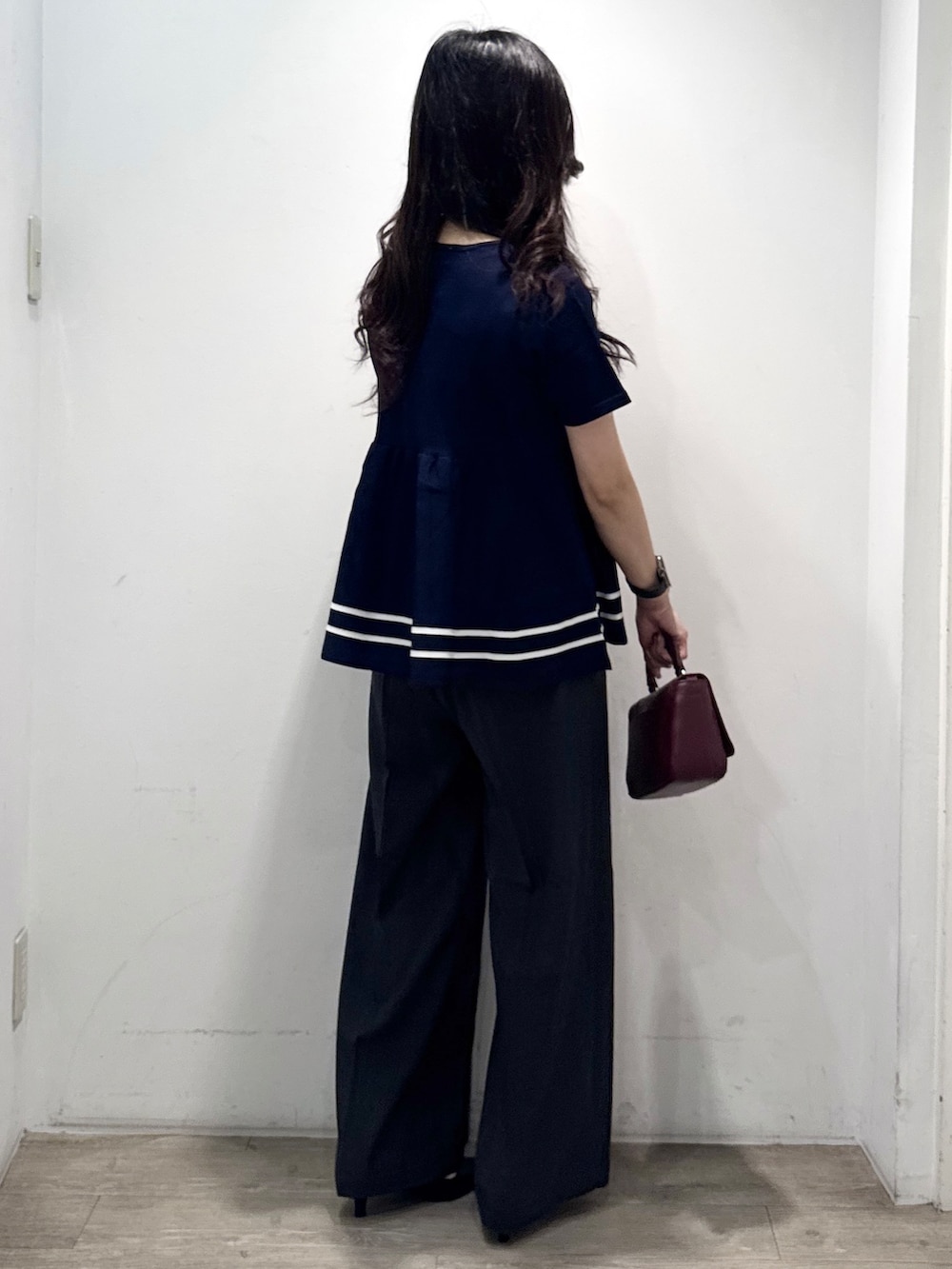 ブルー系のニット/セーター、グレー系のその他パンツ、レッド系のショルダーバッグを着用したレディースの夏コーディネートの10枚目の写真