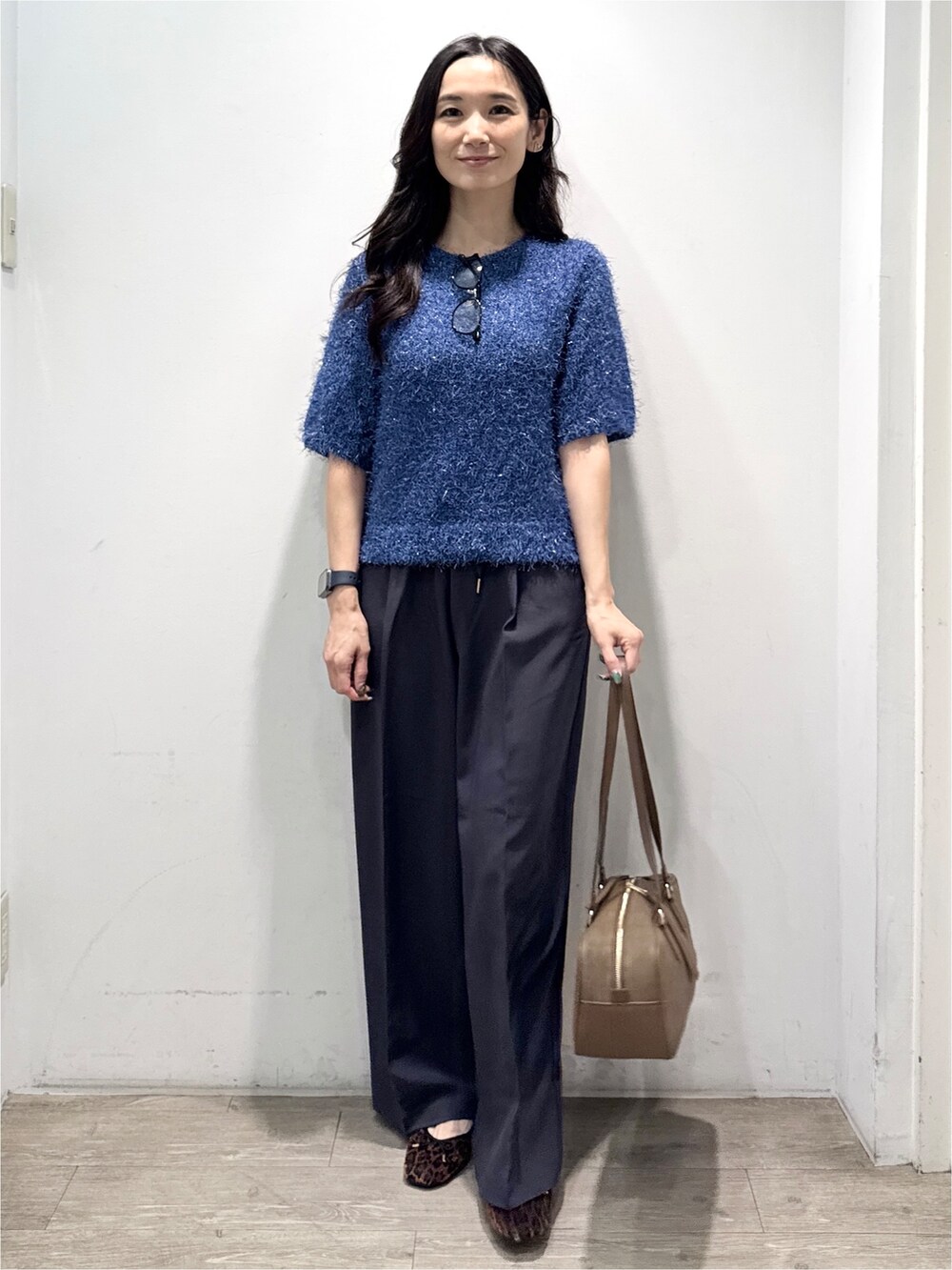 ブルー系のニット/セーター、グレー系のその他パンツ、イエロー系のボストンバッグを着用したレディースの秋コーディネートの6枚目の写真