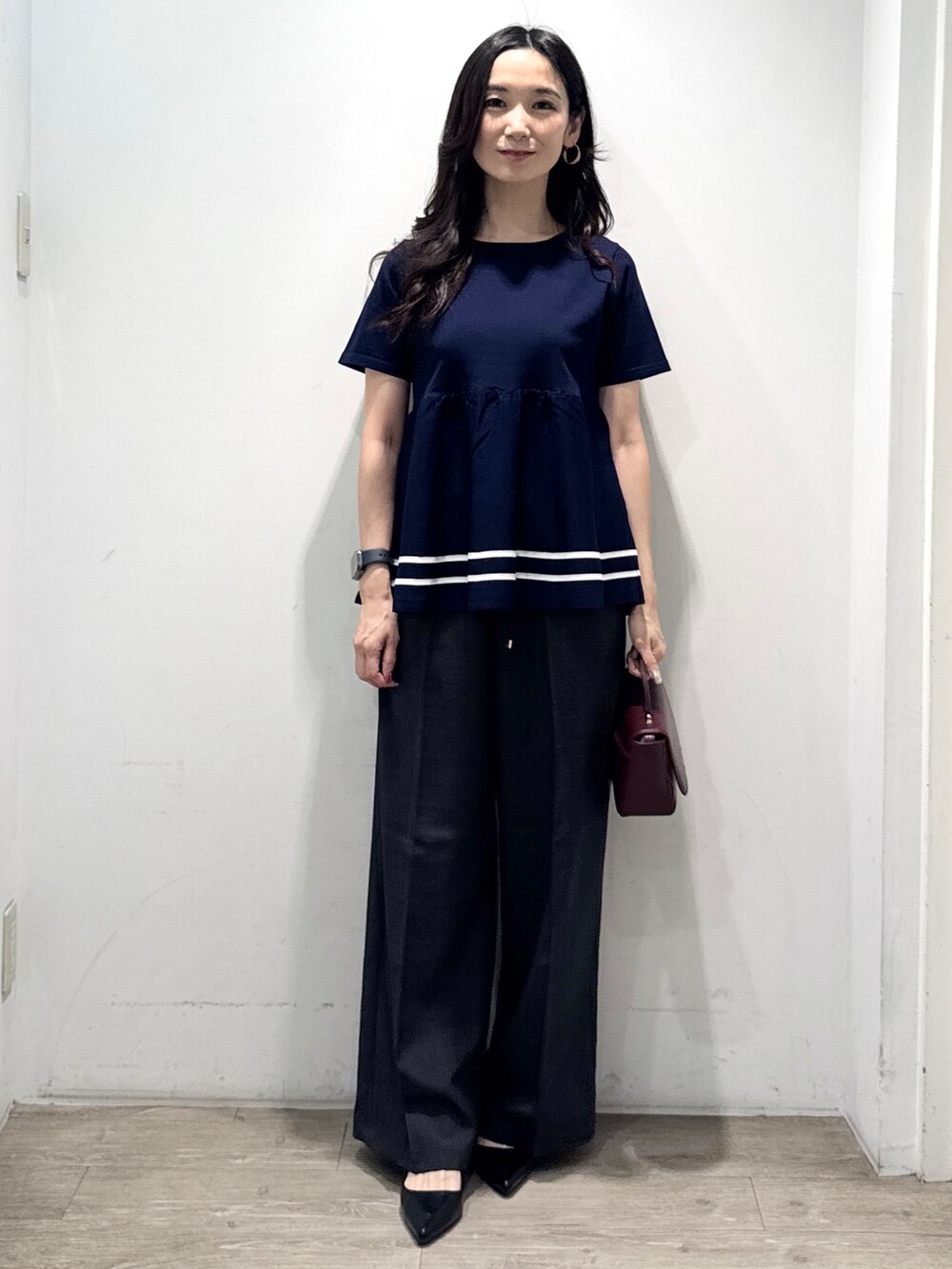 ブルー系のニット/セーター、グレー系のその他パンツ、レッド系のショルダーバッグを着用したレディースの夏コーディネートの7枚目の写真