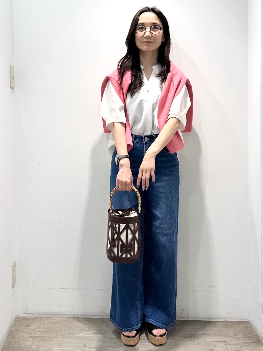 ブルー系のデニムパンツ、ホワイト系のシャツ/ブラウス、ブラウン系のハンドバッグを着用したレディースの春コーディネートの3枚目の写真