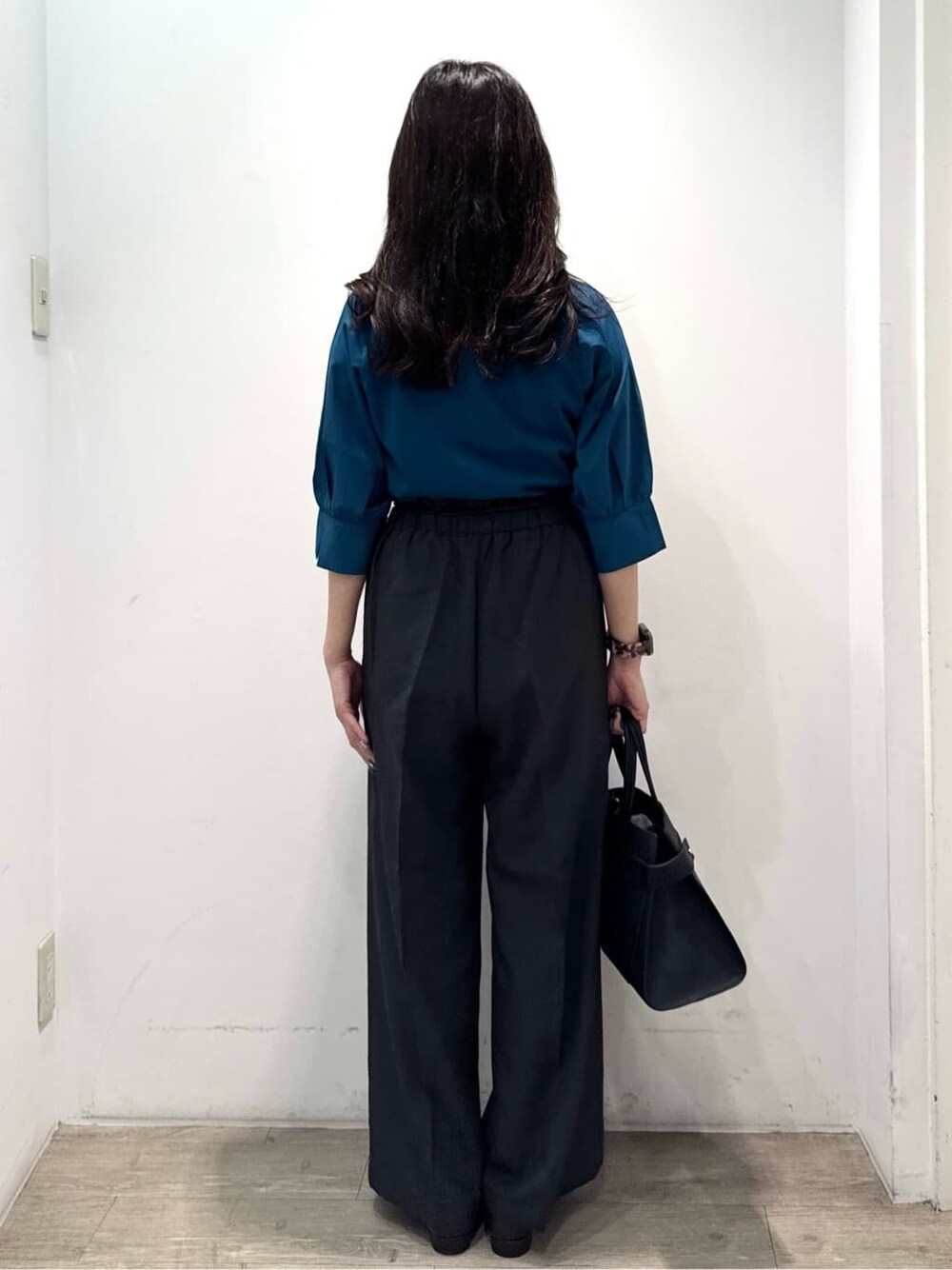 ブルー系のニット/セーター、グレー系のその他パンツ、ブラック系のショルダーバッグを着用したレディースの秋コーディネートの9枚目の写真