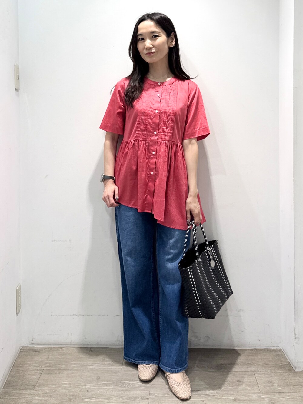ブルー系のデニムパンツ、ブラック系のトートバッグ、ベージュ系のパンプスを着用したレディースの春コーディネートの6枚目の写真